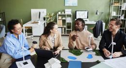People working at a desk wth models of windfarms