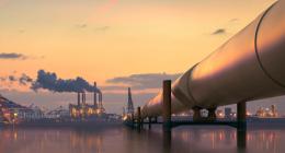 Large pipe going towards a power plant in the background